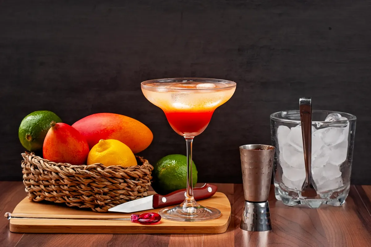 A vibrant cocktail with fresh citrus fruits and ice on a wooden table.