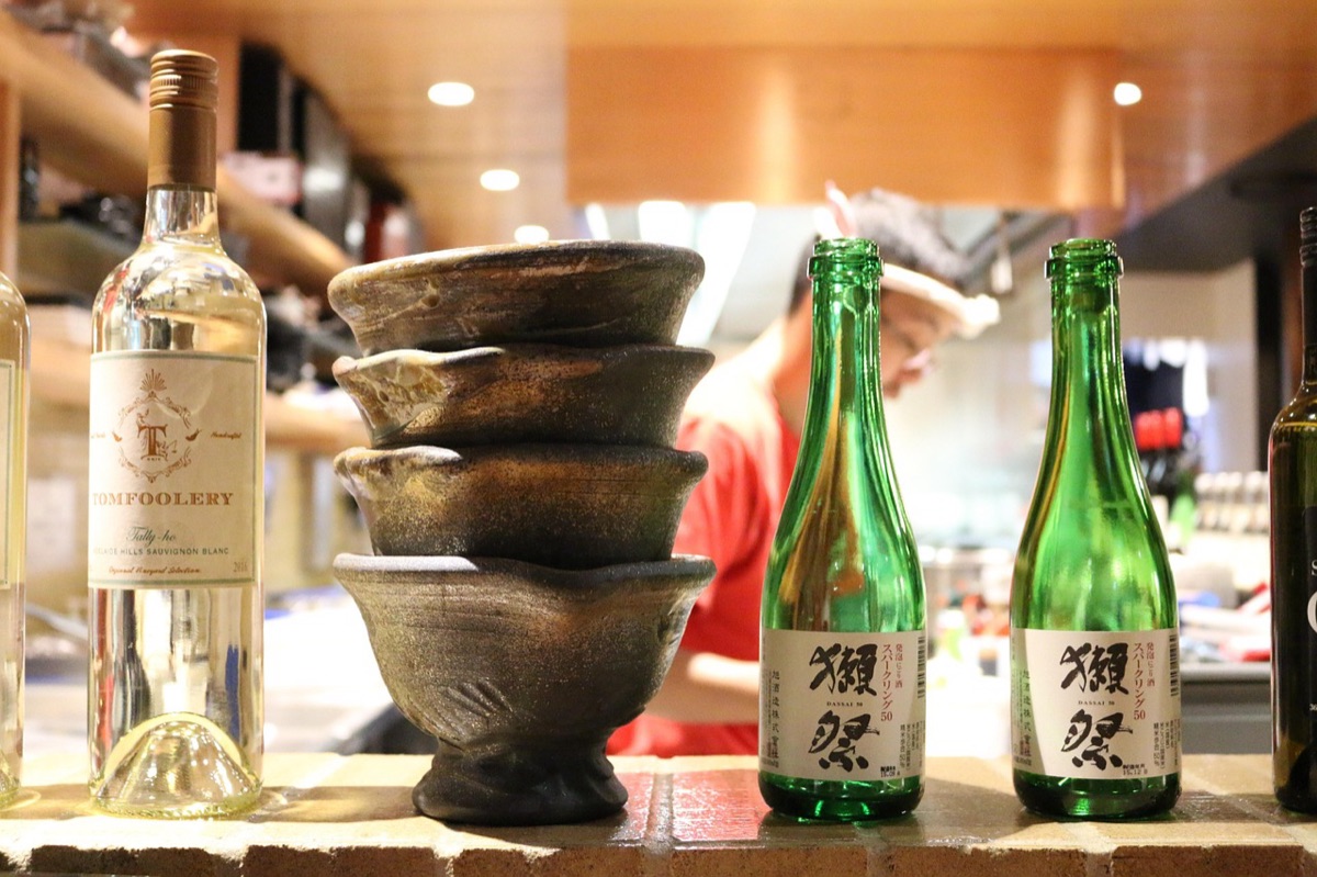 BOTTLE DI SAKE JAPONESI E CASA IN LEGNO