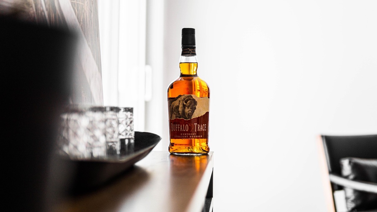 O uivo do whiskey: um bar com copos de whiskey e um fundo de madeira e prata.