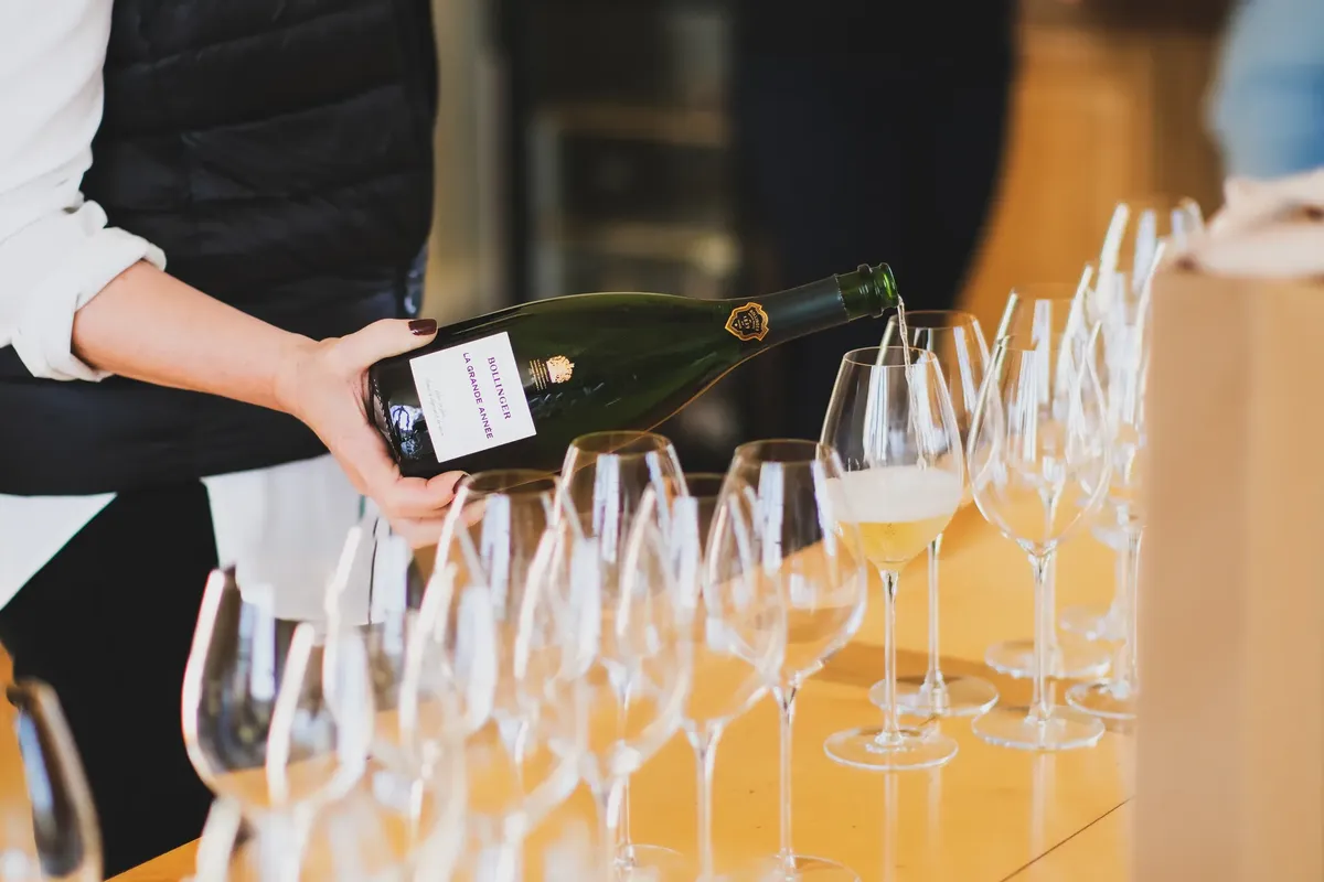 A person pouring champagne at a wine tasting in Aÿ-Champagne, France. Elegance and celebration captured in this moment.